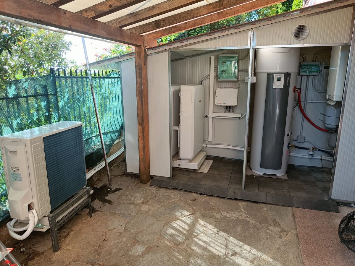 Pompa di calore e bollitore sotto una pergola, installati da OnGrid